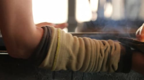 Glass Blower Shaping Orange Sphere of Hot Glass