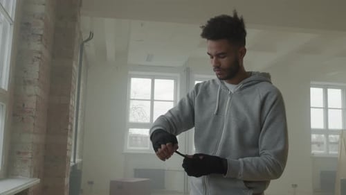 Boxer Wrapping Hands Before Training in Gym