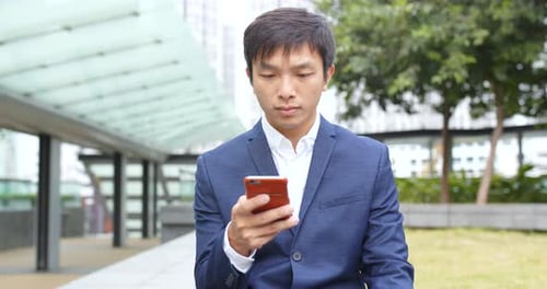 Young Adult Using Phone in Urban Setting