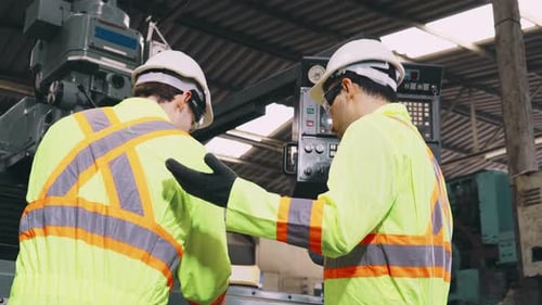 Group of Factory Workers Using Machine Equipment in Factory Workshop