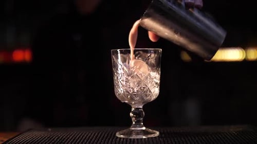 Cocktail Being Poured Over Ice from Shaker