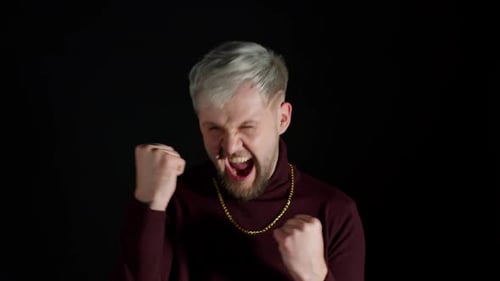 Man Cheers and Clenches Fists in Celebration