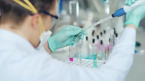 Scientist Uses Pipette in Medical Laboratory