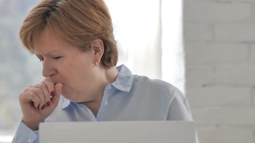 Adult Woman Coughing While Using a Laptop