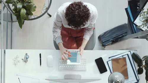 Top Down of Businesswoman Working on Digital Tablet at Office Desk