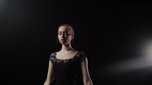 Female Ballet Dancer Performing Gracefully in Dark Studio