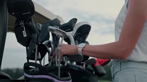 Woman Selecting Golf Club on Rural Golf Course
