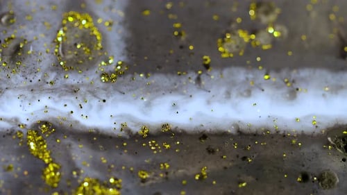 Makro-Nahaufnahme von goldenem nassem Glitter. Goldener Raum-Hintergrund mit glitzernden Partikeln
.