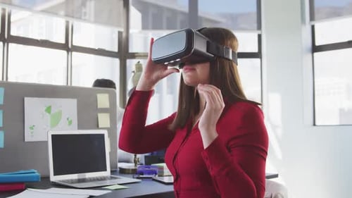 Businesswoman using VR headset in modern office