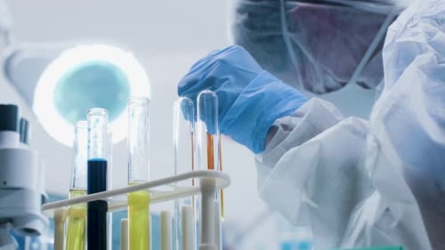 Scientist Mixing Liquids in Test Tubes in Lab