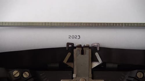Typing 2023 on retro typewriter. Close up.