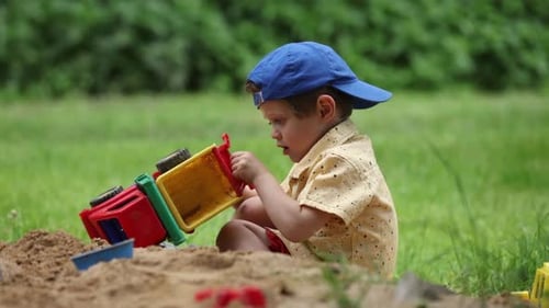 Young Boy Playing With Truck Toy Outdoors