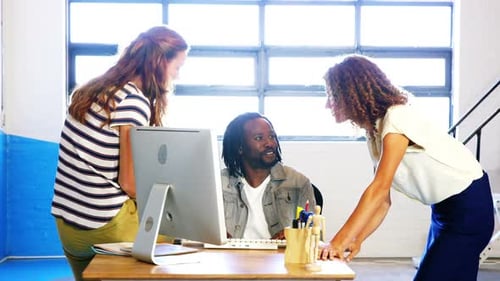 Team Collaborates Around Computer in Modern Office