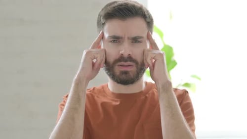 Man Rubbing Temples Due To Headache or Migraine
