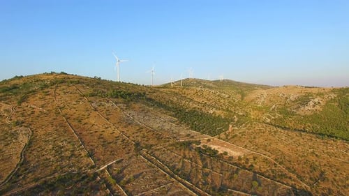Aerial view of group of windmills on a sunny hill