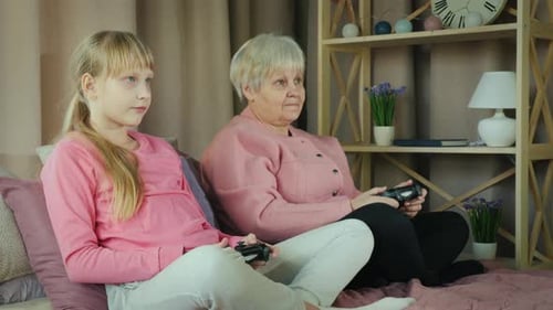 Child and Senior Woman Play Video Games Together