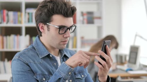 Young Adult Using Smartphone in Office Setting