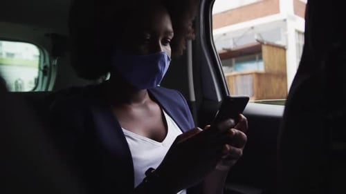 Mujer afroamericana con máscara facial en el coche