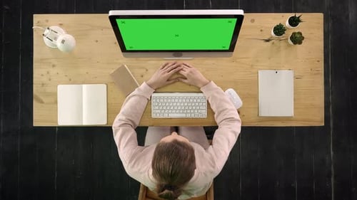Young Woman Looking on the Monitor of Computer. Green Screen Mock-up Display