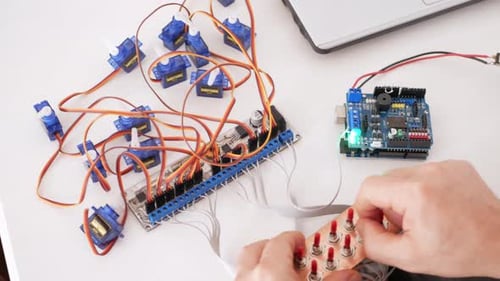 Male Programmer Creates Robotics an Arduino Board Controls Servo Motors
