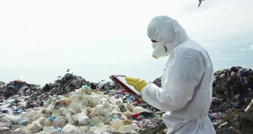 Figure in Hazmat Suit Using Tablet at Dump