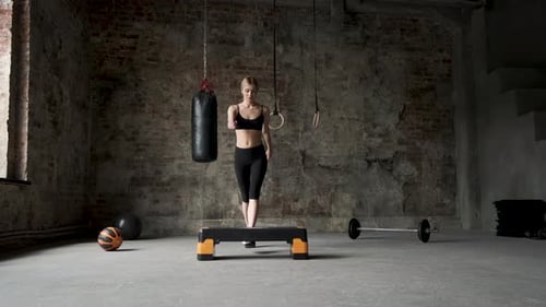 fit girl doing aerobic workout in gym. caucasian woman trains lose weight indoors