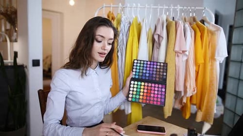 Woman Presents Makeup Palette in Fashionable Home Setting