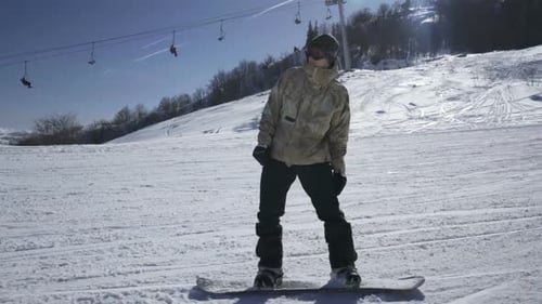 Snowboarder genießt an einem sonnigen Tag eine Bergfahrt in einem Skigebiet