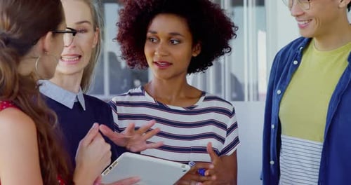 Colleagues Discussing Technology in Bright Office Space