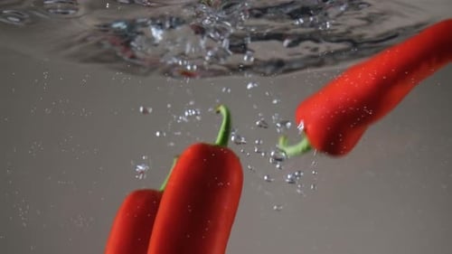 Red Peppers Falling into Water Making Bubbles