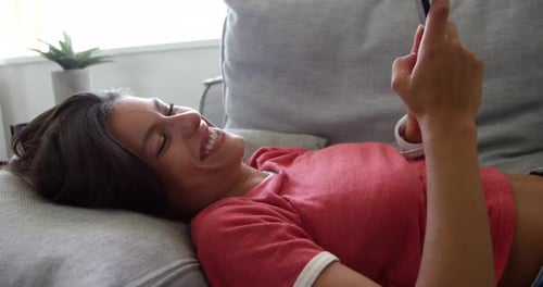 Woman Relaxing on Couch with Smartphone