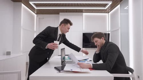 Businessmen Discussing Charts and Graphs in Bright Office