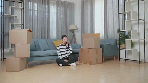 Woman Talking on Phone Surrounded by Moving Boxes