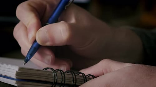 Close Up Futage of Man Writing Notes in Notebook