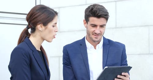 Business Professionals Collaborating on a Tablet Outdoors