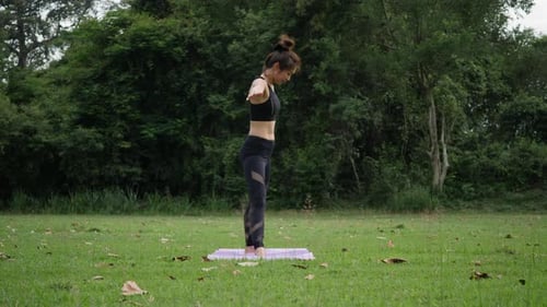 Beautiful woman is doing Yoga in Park