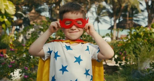 Boy in Superhero Costume Posing in Tropical Garden
