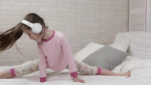 Girl Dances in Split with Headphones on Bed