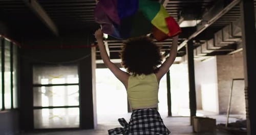 Young Adult Holding a Pride Flag in Building