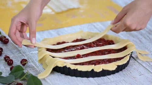 Hands Weaving Dough on a Delicious Cherry Pie