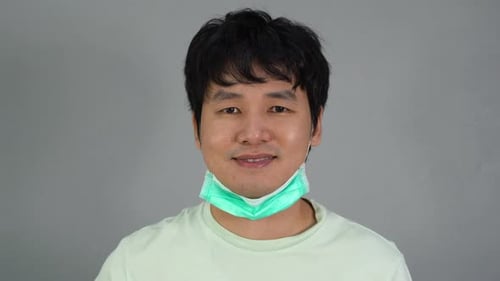 man removes a medical mask (surgical mask) and smiling