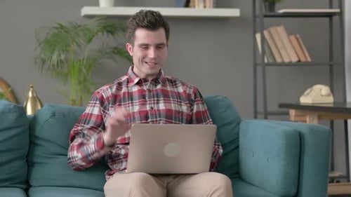 Man Using Laptop for Video Call on Couch