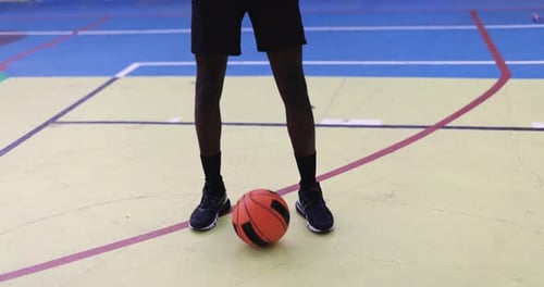 Junger afrikanischer Mann spielt Basketball im Freien - College-Sportkonzept