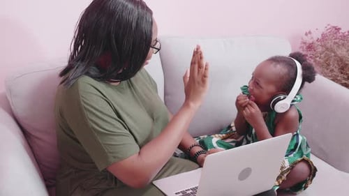 Woman and Child Enjoying Laptop Together at Home