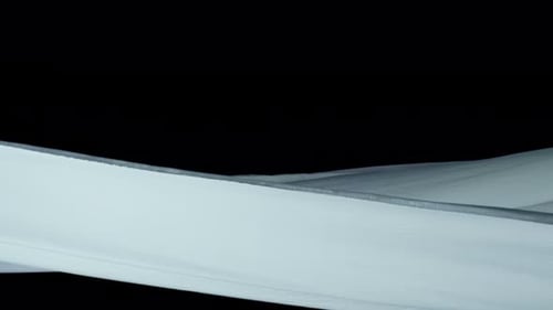 White Fabric Flowing Across Black Background
