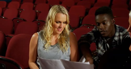 Actors Reviewing Script in Empty Theater