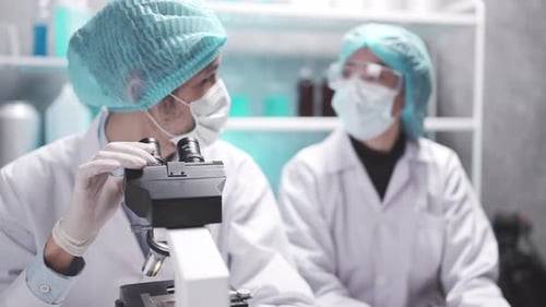 Scientist team has researching in the laboratory microscope and analysis results in the laboratory