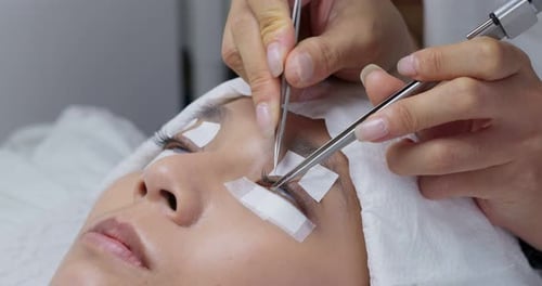 Procedimento de extensão de cílios, estilista profissional alongando cílios femininos