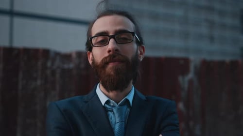Bearded Man Putting on Glasses in City