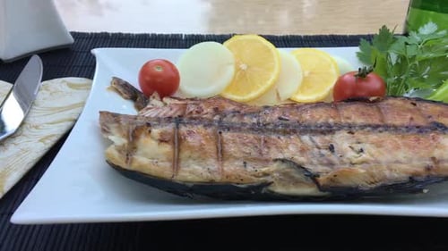 Grilled Fish Plated with Fresh Vegetables and Lemon